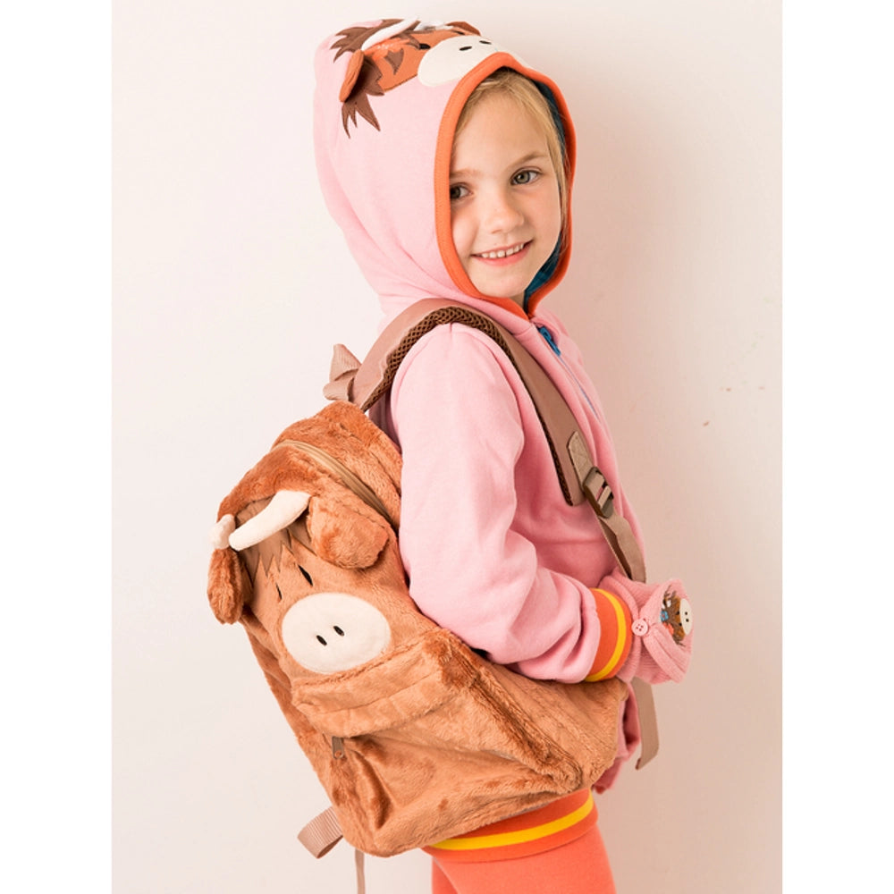 Child wearing a pink hoodie with a horse design and a matching highland cow-shaped backpack on a light background