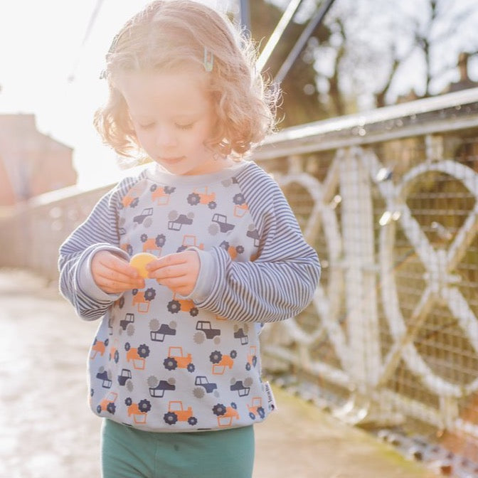 little girl wearing tractor sweatshirt from Toucan Blue | Cotswold Baby Co