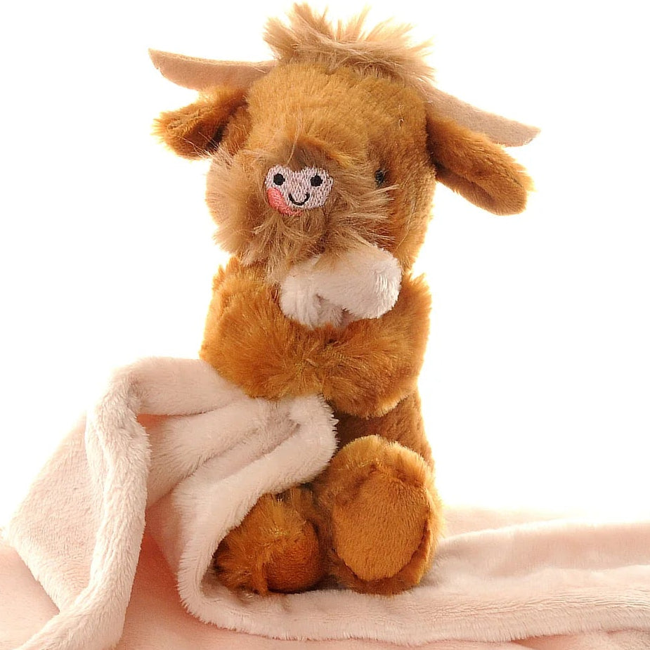 Plush highland cow softf toy with a heart shape nose and horns holding a cream blanket