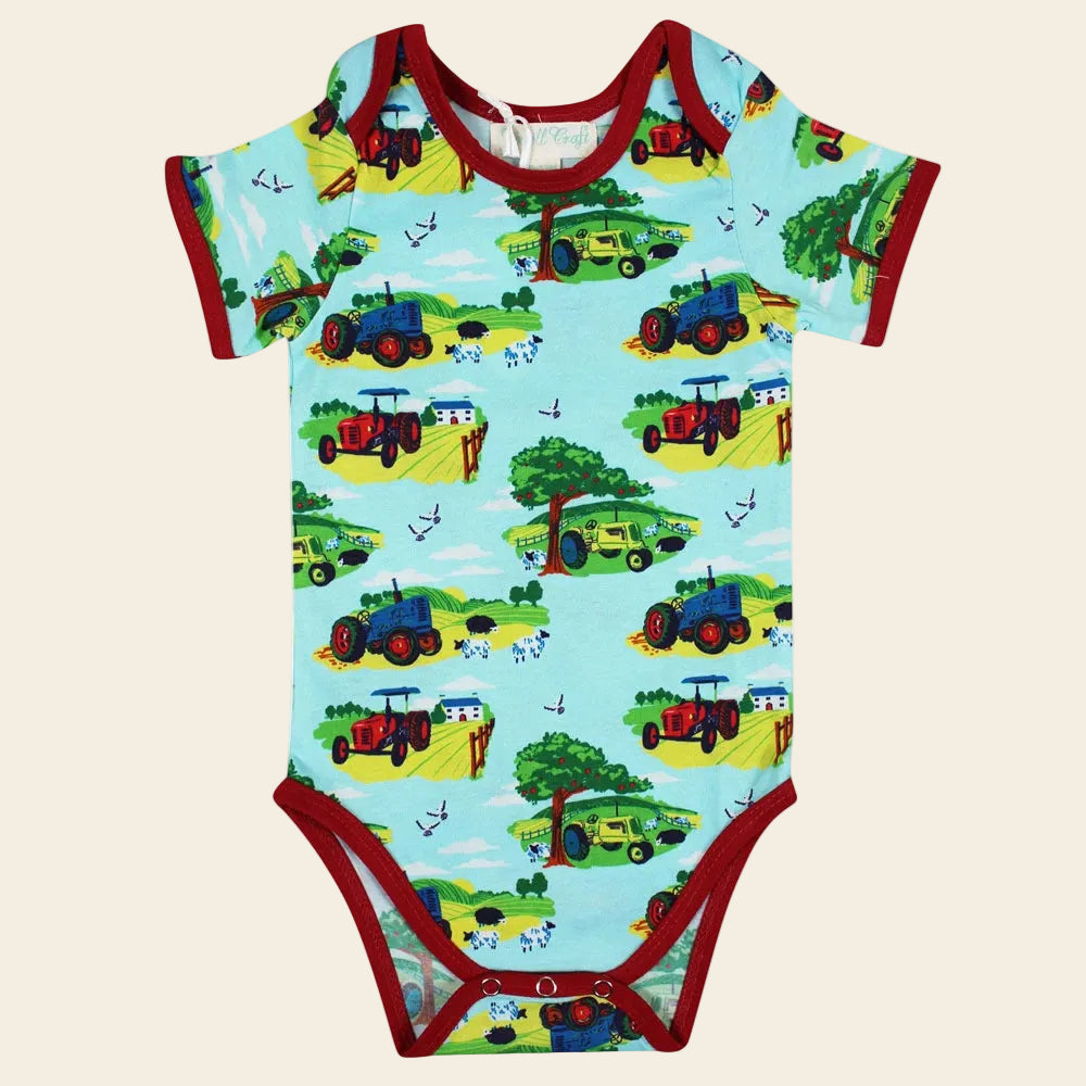 Baby onesie with tractor pattern on a white background