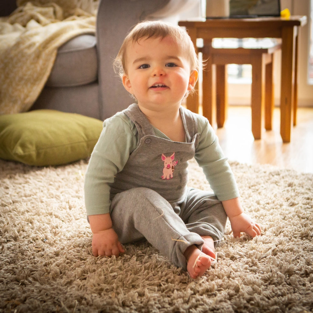 toddler sitting in a lounge in front of a sofa