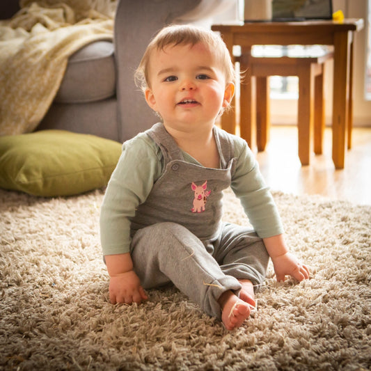 toddler sitting in a lounge in front of a sofa