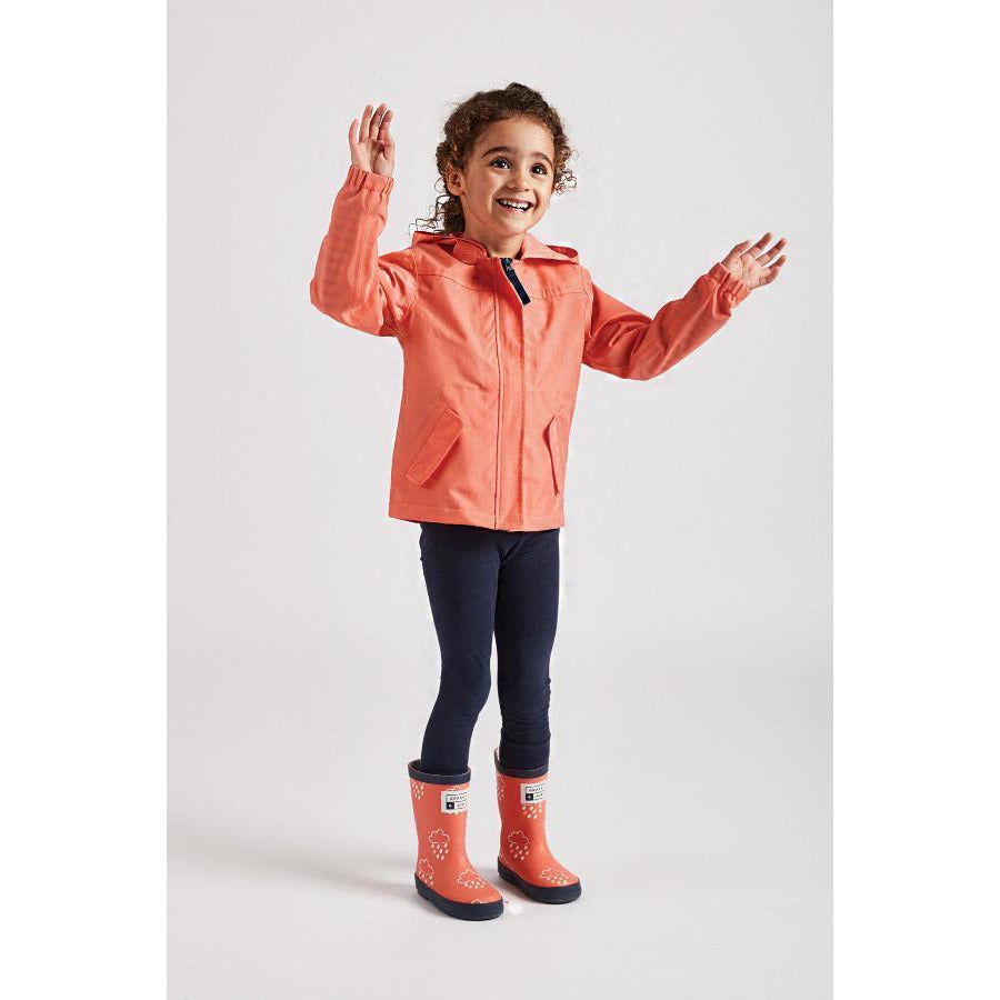 Girl wearing coral rain cheater waterproof coat by Grass and Air - Cotswold Baby Co