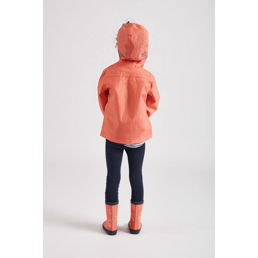 Girl wearing coral rain cheater waterproof coat by Grass and Air - Cotswold Baby Co