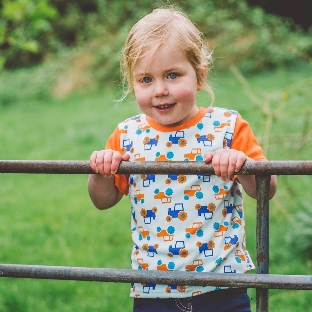 Little Girl wearing Orange & Aqua Tractor T-shirt by Toucan Blue | Cotswold Baby co